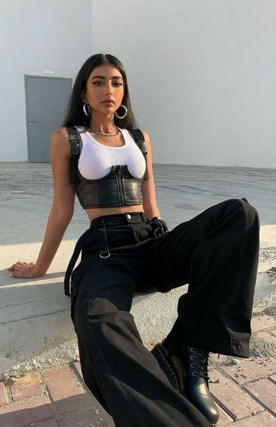 Avec un pantalon large et des bottes